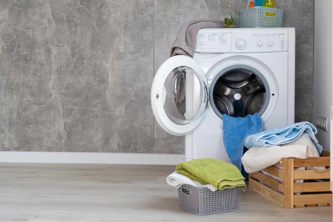 Práčka so sušičkou v práčovni a koše s prádlom
