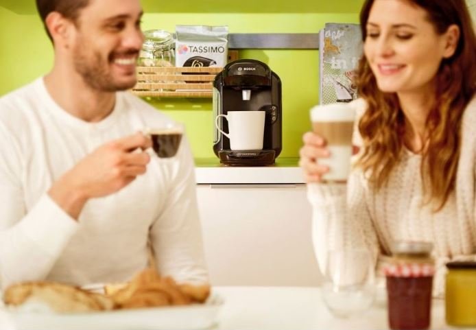 Muž a žena pijú kávu pripravenú v Bosch TAS 1402 Tassimo Vivy 2