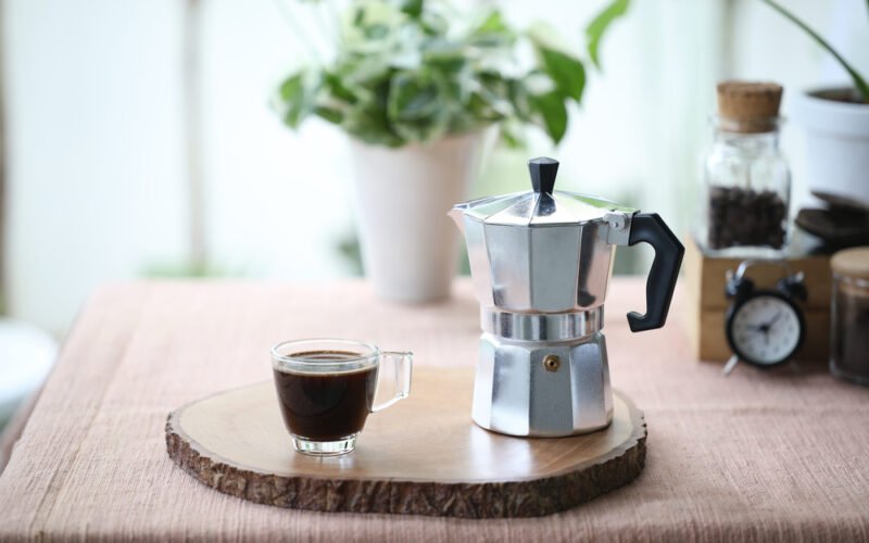 Moka koťogo kávovary, kanvičky - kávovar a šálka s kávou na drevenej podložke