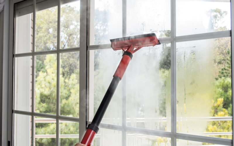 Čistenie okna dlhým červeným parným čističom 