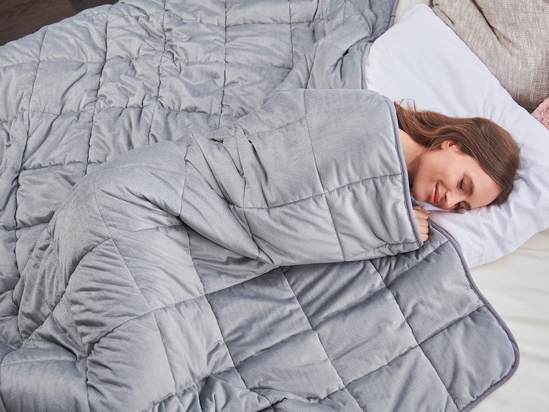Žena spí pod antistresovou prikrývkou