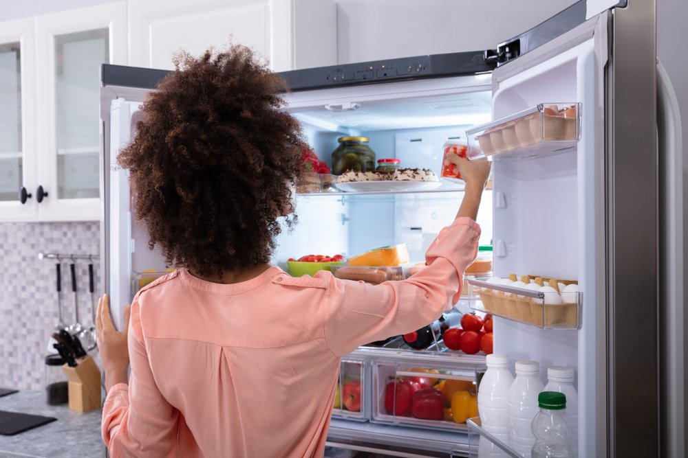 žena vyberá potraviny z americkej chladničky