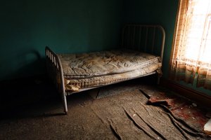 Starý, špinavý matrac na posteli v izbe za prirodzeného svetla