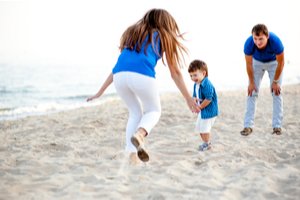 Žena s mužom a dieťaťom na pláži