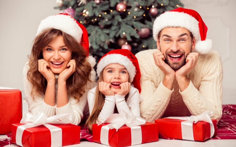 Rodinka vo vianočných čiapkach s darčekmi