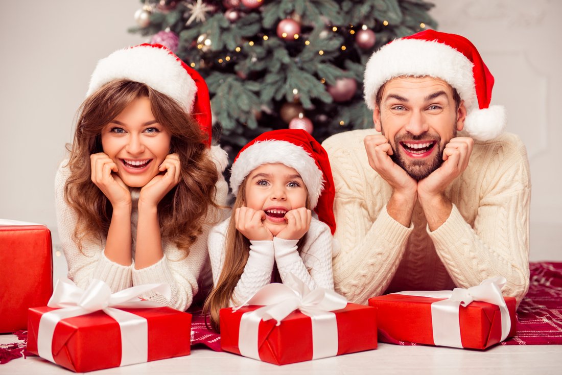 Rodinka vo vianočných čiapkach s darčekmi