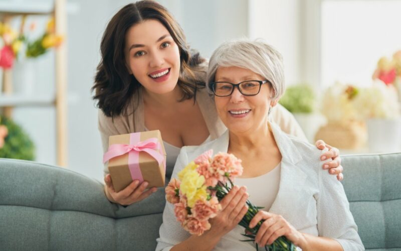 Žena s darčekom a jej matka s kvetmi