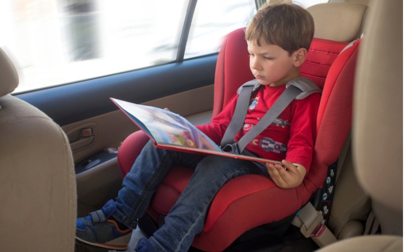 Autosedačky od 9 do 36 kg - bezpečnosť dieťaťa je najdôležitejšia, chlapec v autosedačke čítajúci knihu
