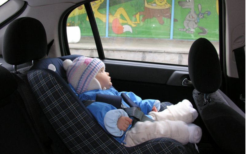 Dieťa v zimnej bunde sedí v autosedačke