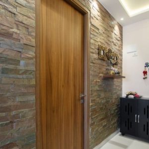 Hnedé dvere s kamenným obkladom na stene