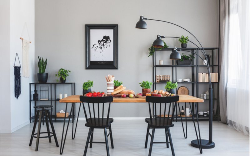sivá jedáleň s čiernymi policami, dreveným jedálenským stolom a čiernymi stoličkami