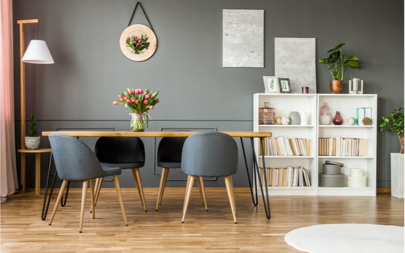 útulný interiér so šedými stenami, obdĺžnikovým jedálenským stolom z masívu a šedými čalúnenými stoličkami