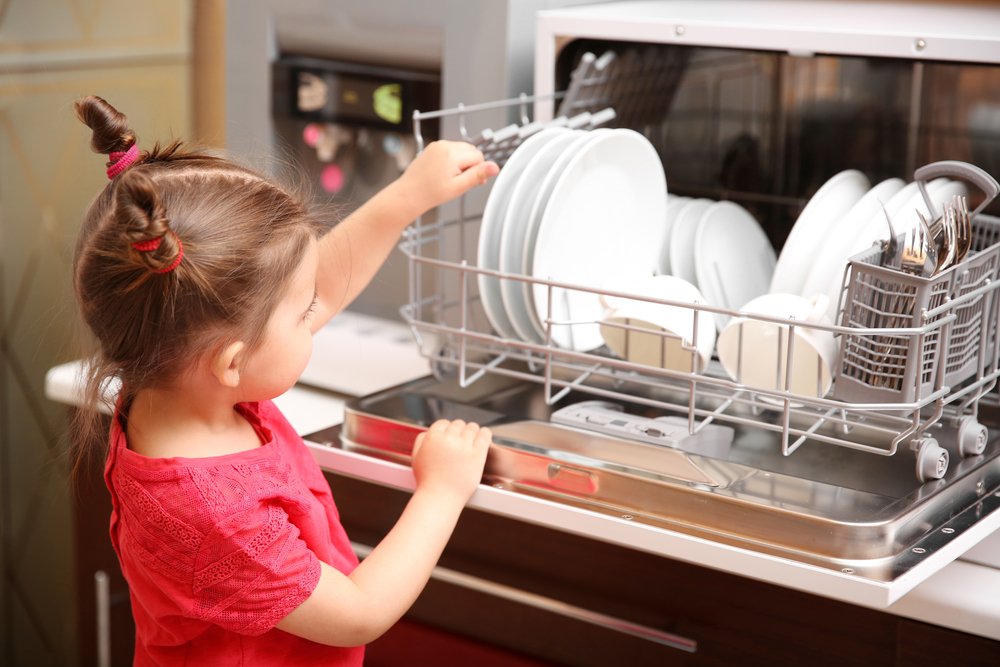 Dievčatko vykladá riad zo stolnej umývačky riadu
