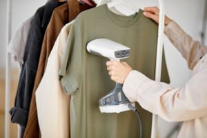 Žena používa elektrický naparovač odevov 
